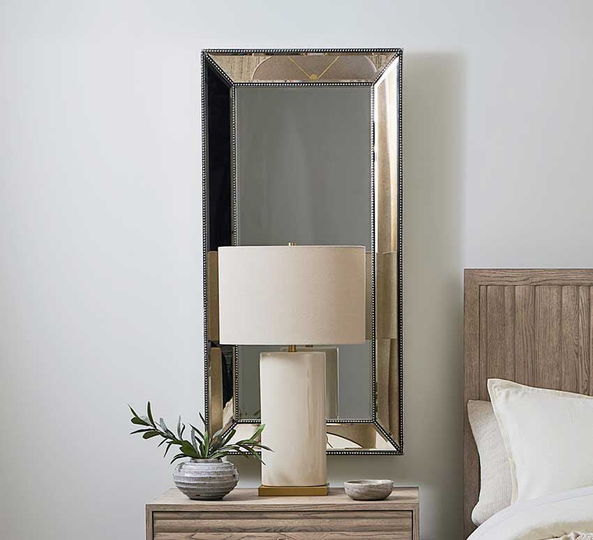 Lamp on nightstand with mirror on the wall
