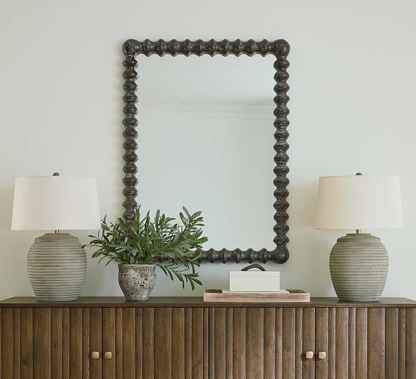 Mirror on wall with lamps on crendenza