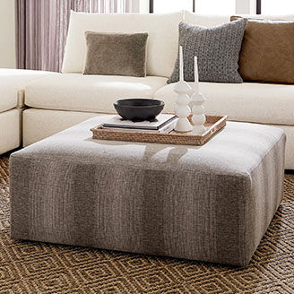 Striped ottoman in front of white sectional