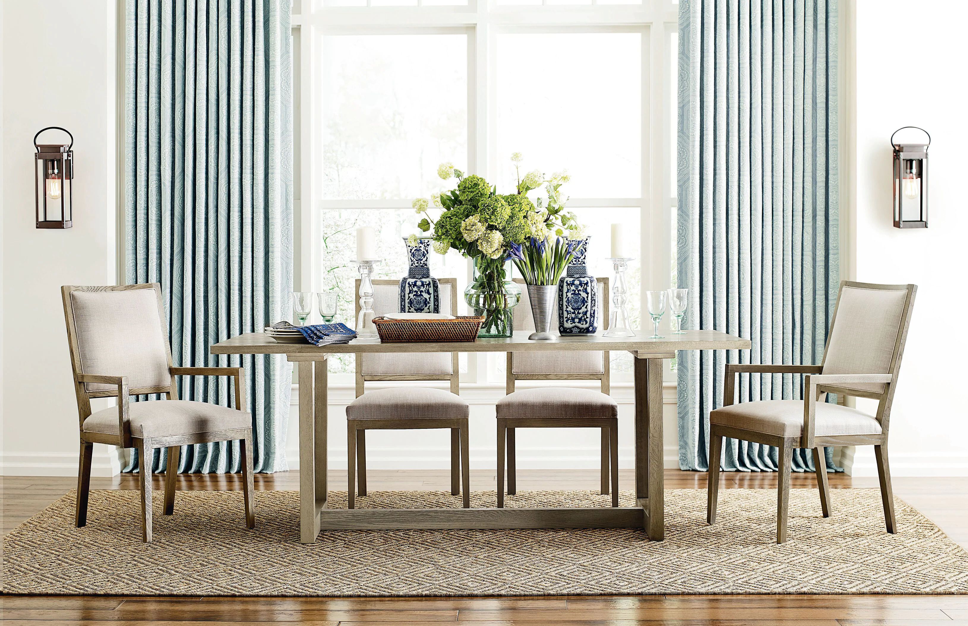 bright dining area with large window, framed by blue curtains