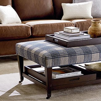 Plaid ottoman in front of brown sofa