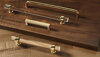 Several drawer bulls and handles in a variety of materials presented on a wood board