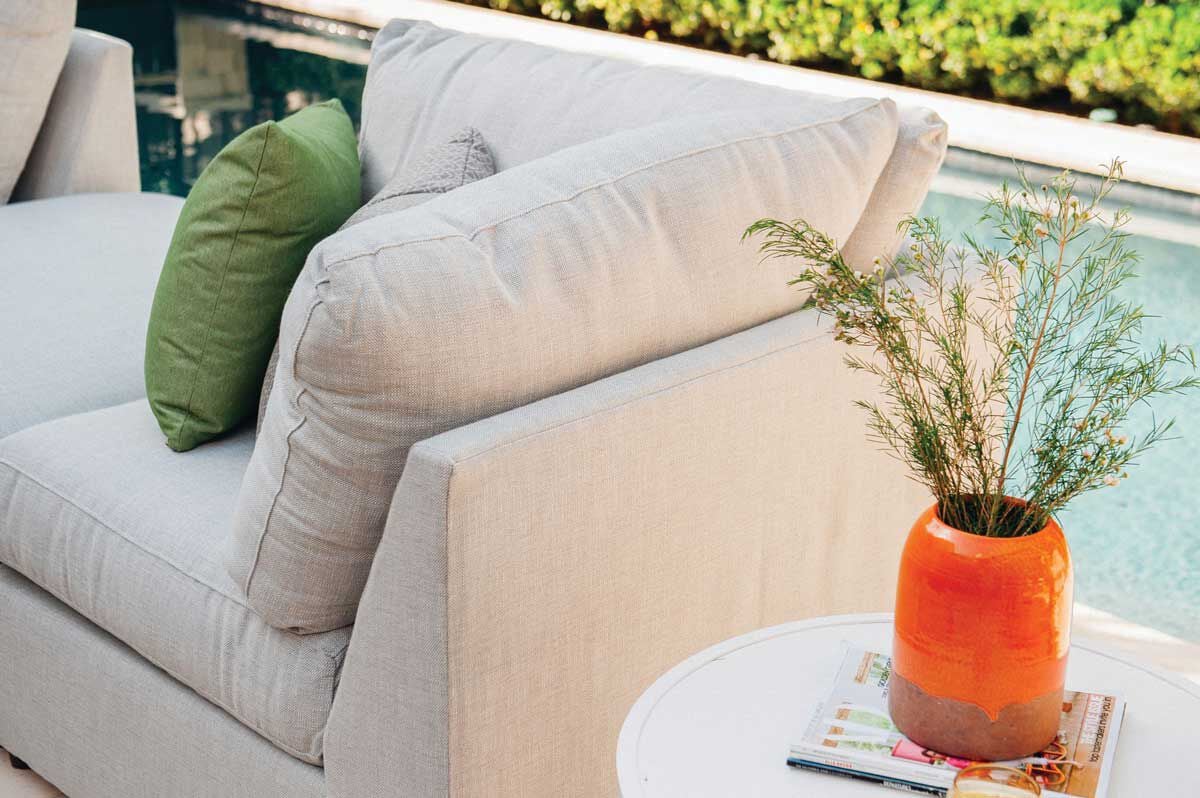 poolside couch with cushions and plant