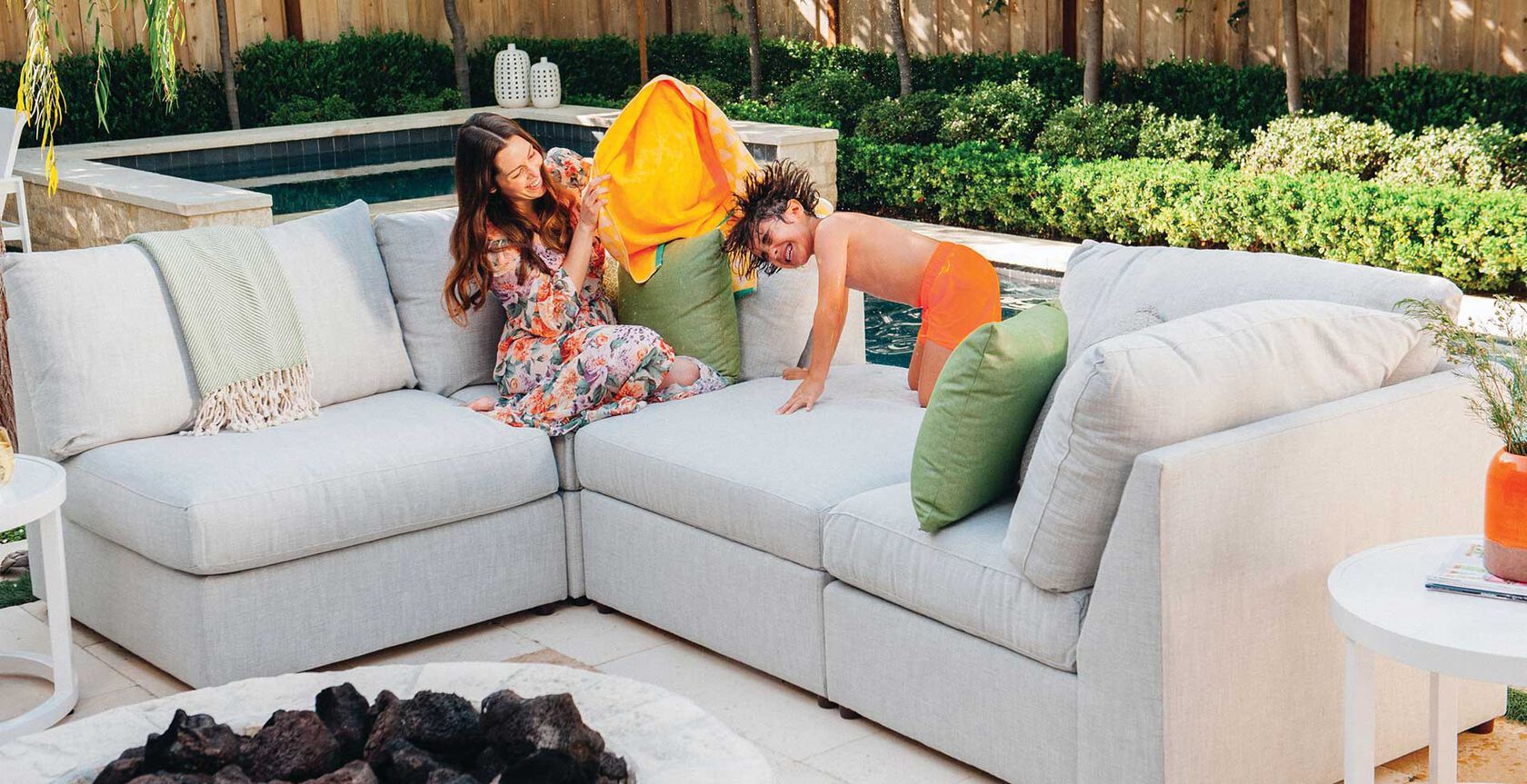 mother and son playing on a couch, poolside