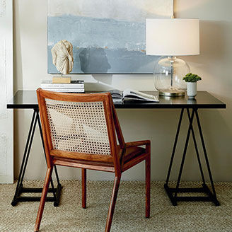 Desk with chair against wall with painting