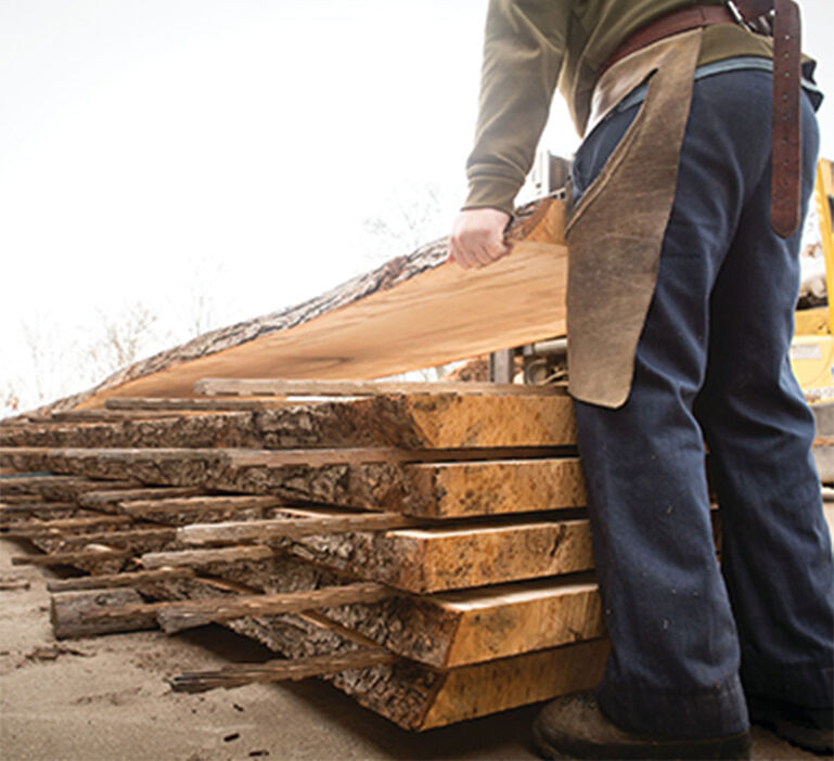 Wood worker lifting lumber