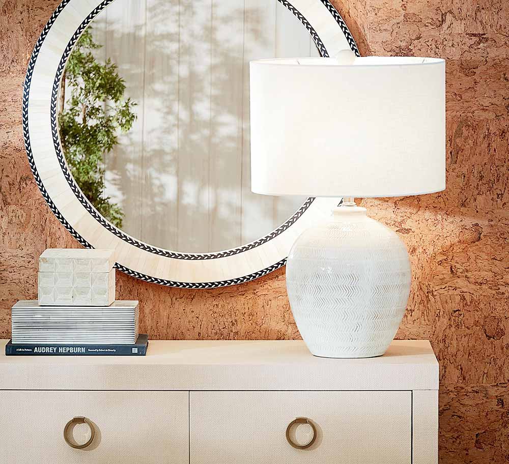 Console table with lamp and a mirror on the background wall